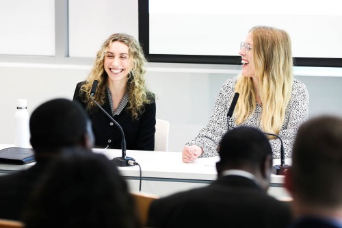 Two women smiling, laughing with each other.