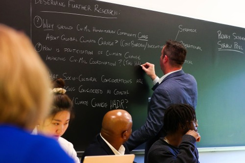 Man writing on a chalk board.