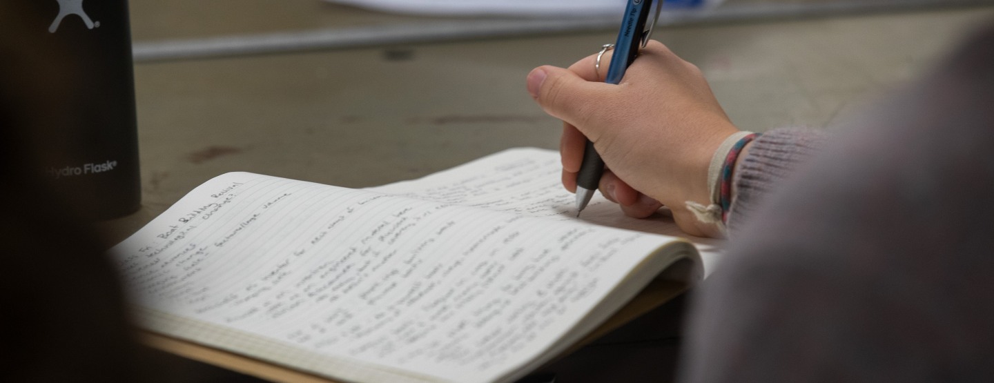 Student writing in notebook