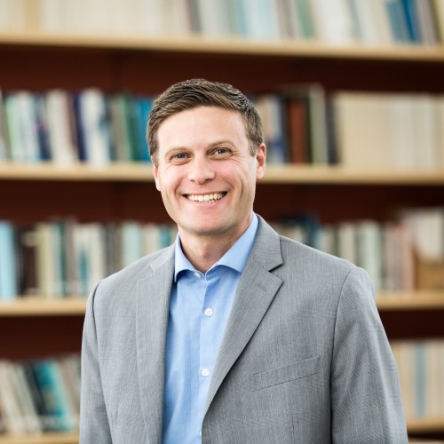 Image of Dr. Adam C. Levine in front of bookshelf
