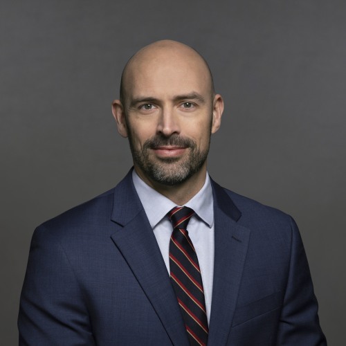 Man in suit looking straight ahead with slight smile