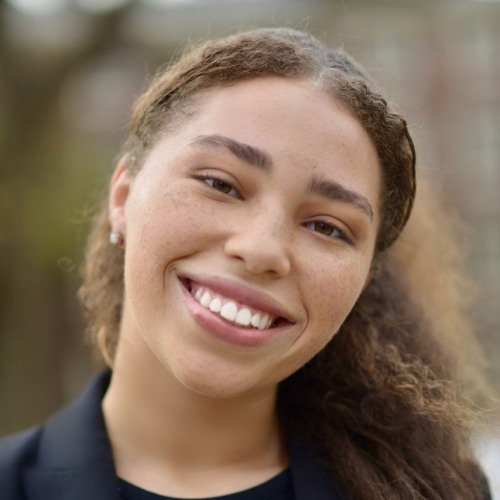 Woman with head tilted smiling at camera. 