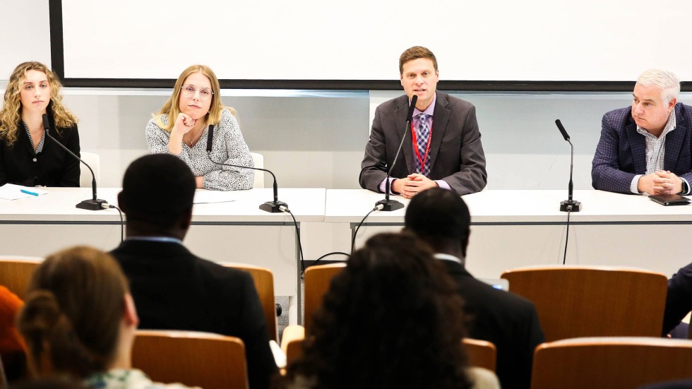 Panel of four individuals speaking with microphones. 