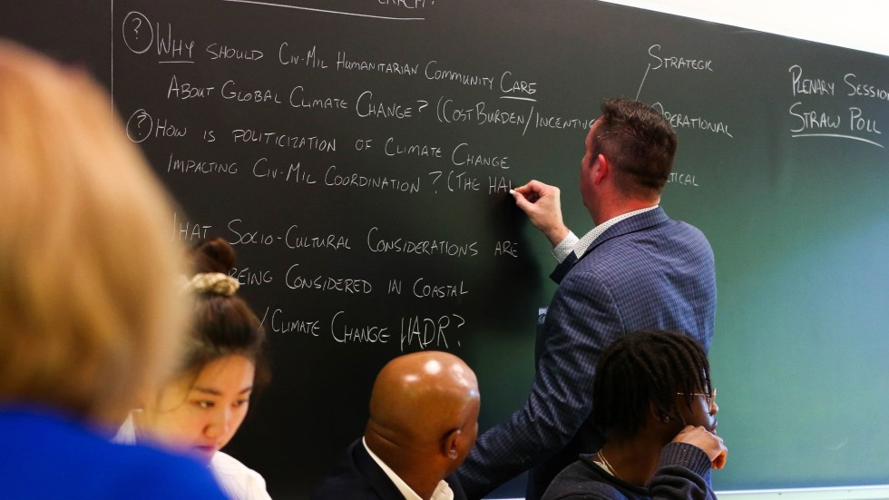 Man at chalkboard writing. 