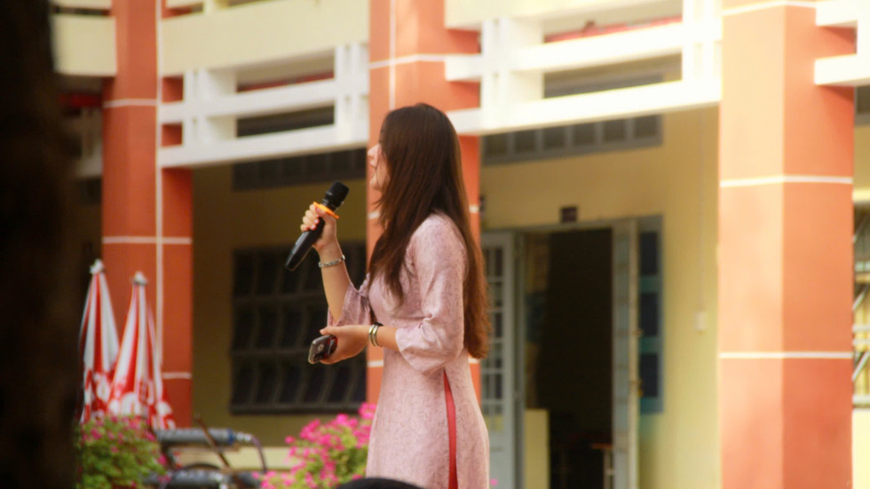 Woman with brown hair speaking at an event